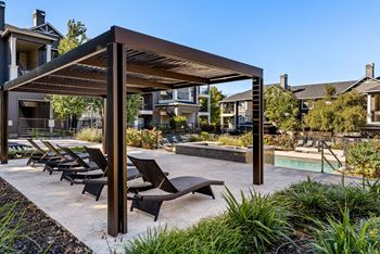 A patio with a pool and sun loungers.